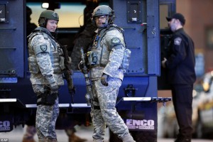 Militarized police stand around aimlessly before and after the blasts in Boston - exposing the "safety" offered to the public in the last 10 years by the growing police state as a mere illusion we have been made to accept, but clearly, to no avail. (AP)
