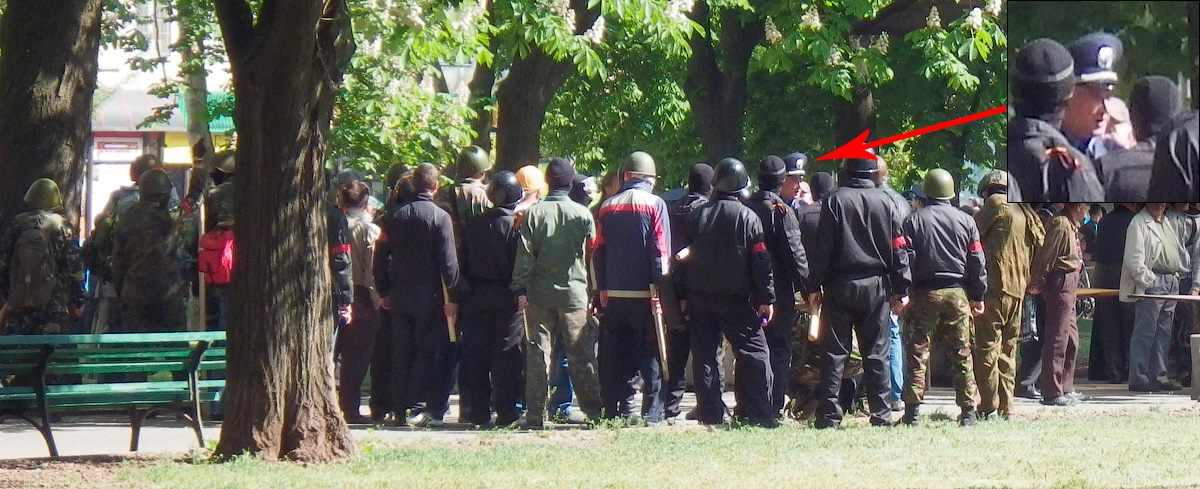 A group of men with red bands receive instructions from a person in police uniform, Odessa, May 2, 2014.