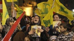 A Hezbollah supporter holds pictures of Lebanon's Hezbollah leader Sayyed Hassan Nasrallah.