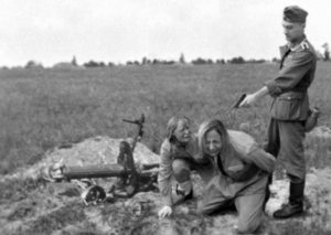 A Nazi soldier gets ready to murder two Soviet Slavic women during Operation Barbarossa, summer 1941. This incident probably took place in the Ukraine or Belarus.