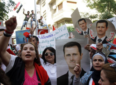 Syrian citizens hold portraits of President Bashar al-Assad as they protest against sanctions outside the EU offices in Damascus, Sept 2011.