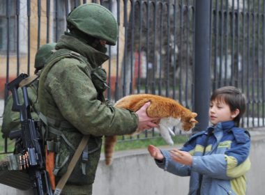 Russian soldier hands a cat to a boy in Crimea, February 2014.