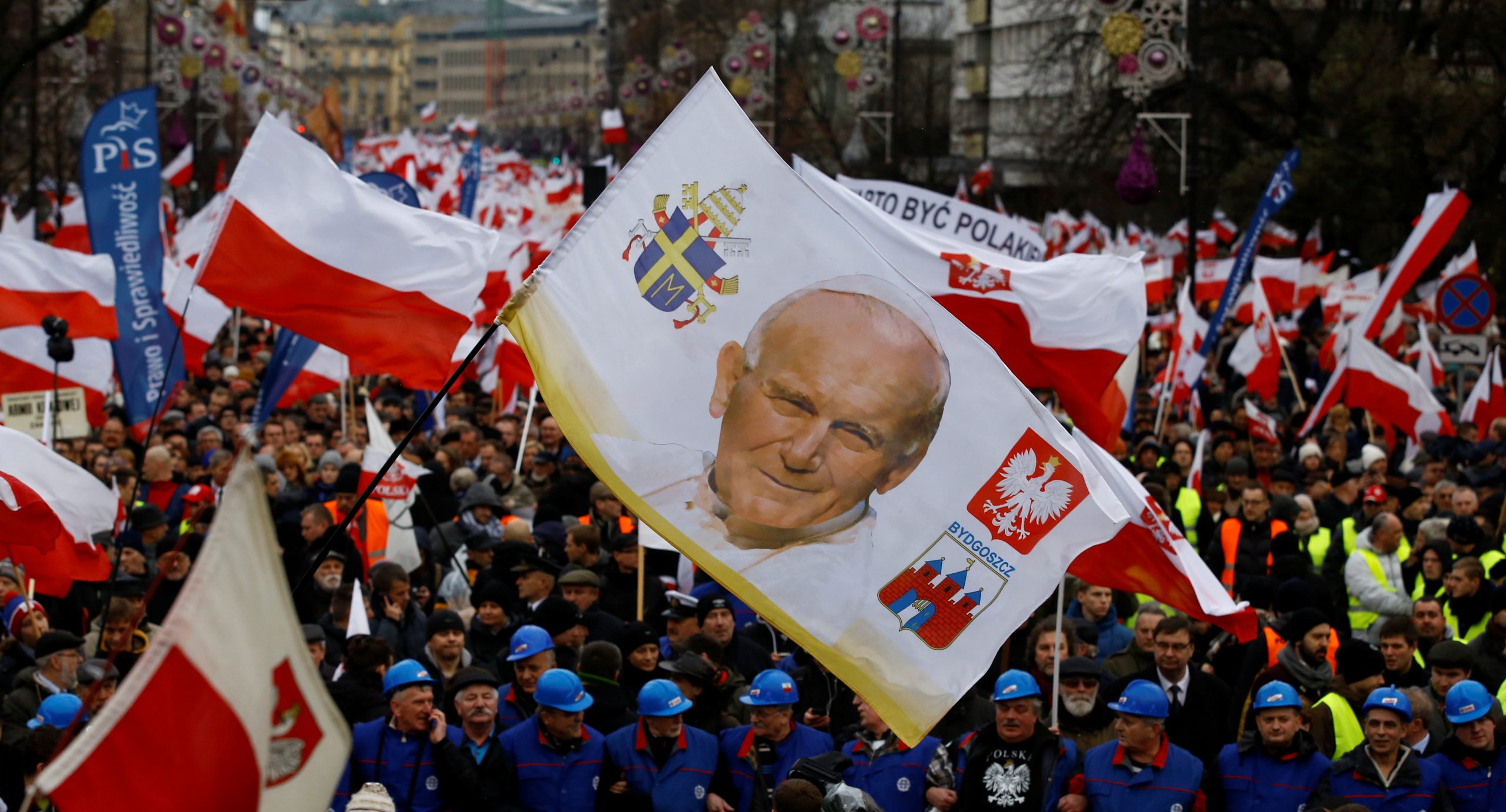 Supporters of Law and Justice party walk with a portrait of late Pope John Paul II during a pro-government demonstration in Warsaw