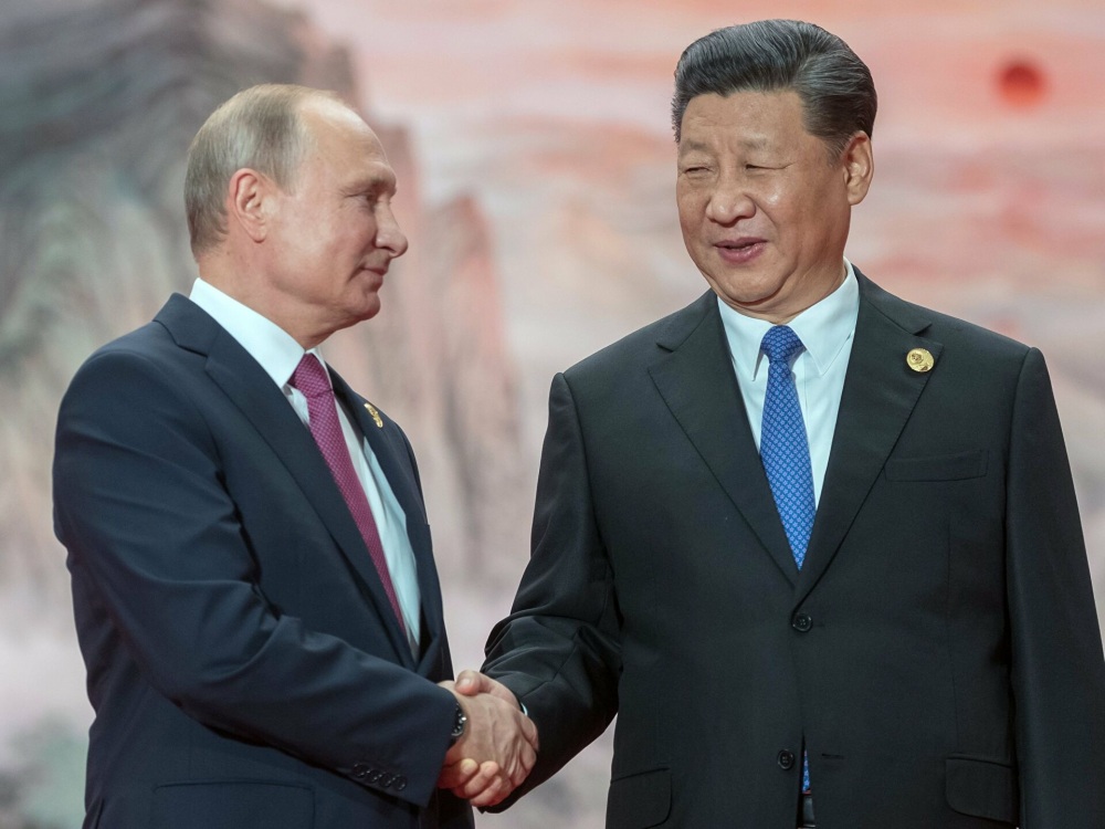 Putin shakes hands with Jinping